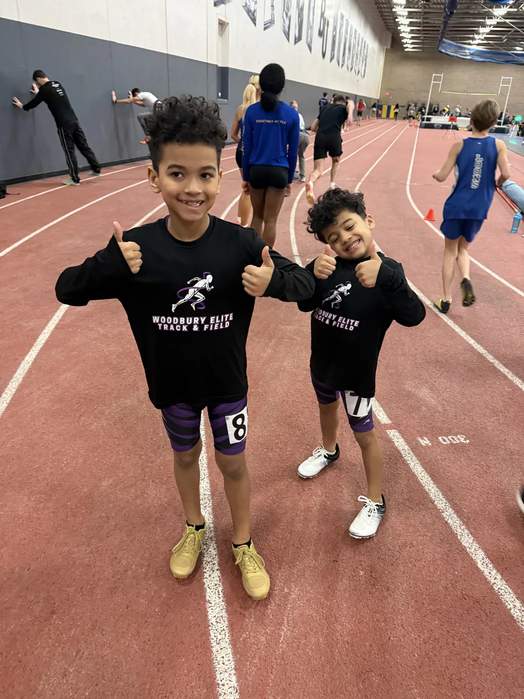 Young Woodbury Elite athletes on an indoor track