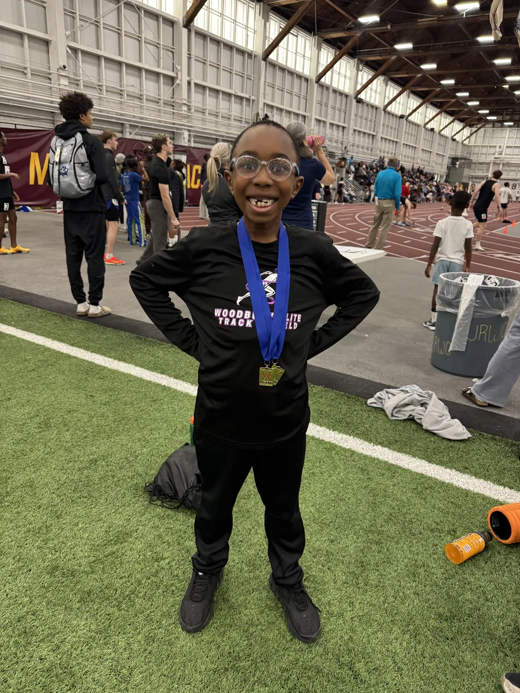 Woodbury Elite athlete wearing a medal at an indoor meet